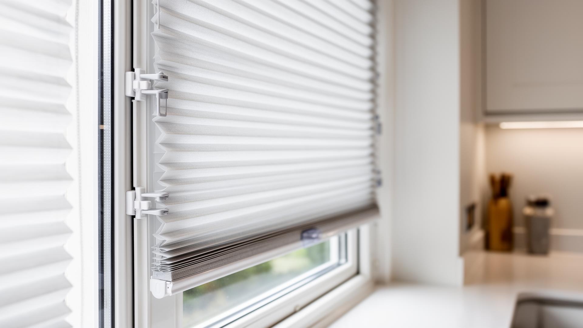 Perfect-fit no-drill pleated blind clipped neatly inside a uPVC kitchen window frame by Shires Shutters