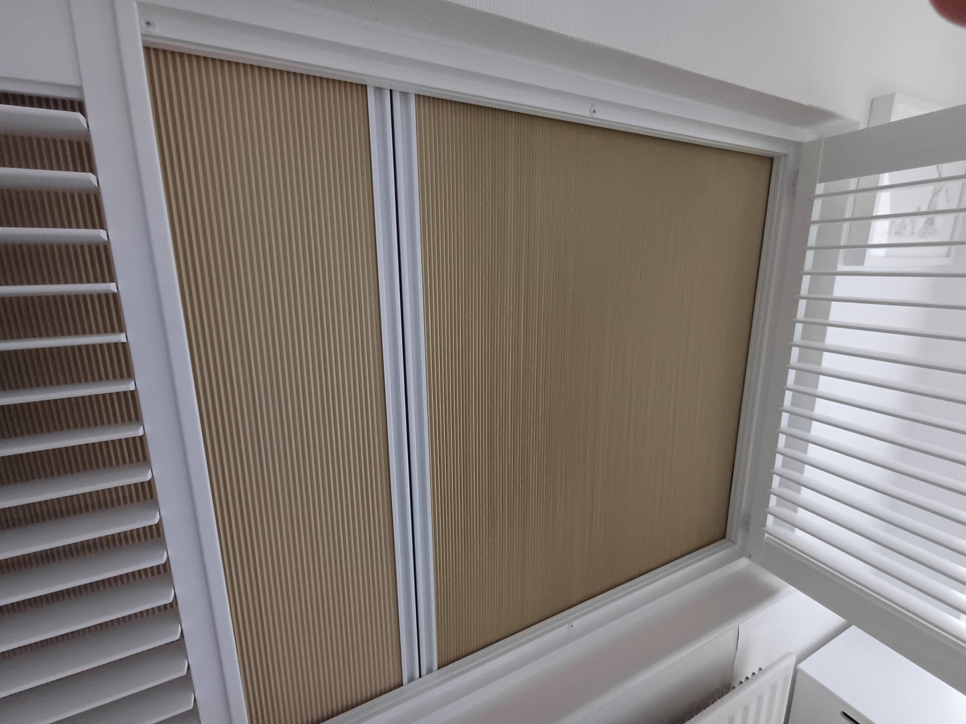 Cream honeycomb thermal pleated blinds fitted for energy efficiency by Shires Shutters