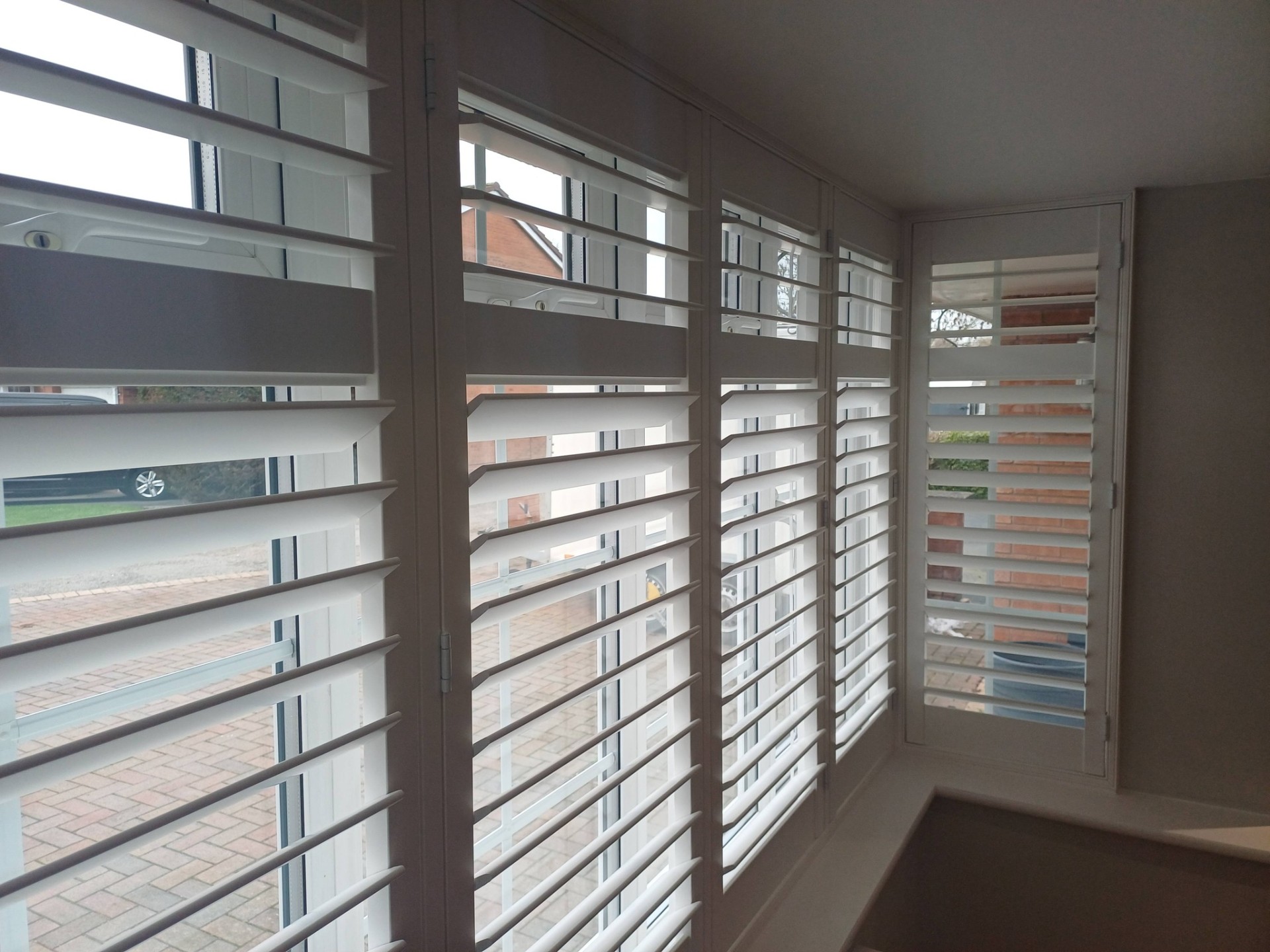 Full-height made-to-measure plantation shutters fitted to a five-panel bay window by Shires Shutters